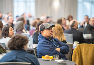 Man in hat listening to speaker