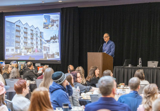 Presenter showing development on screen in front of crowd