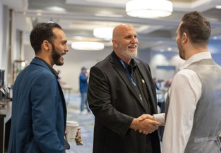 Three men introducing themselves and shaking hands