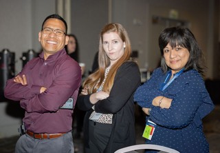 Group of three professionals posing with arms crossed