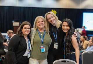 Group of four professional women posing for a photo