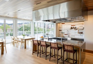 Community kitchen with bar seating and view of outdoor terrace