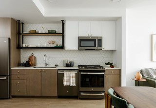 Apartment kitchen with stainless steel appliances and tile backsplash