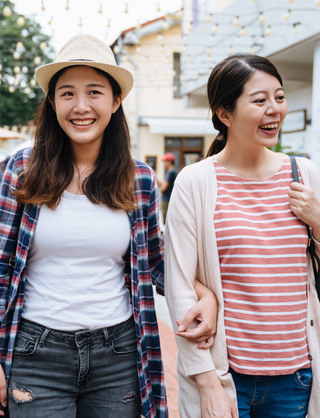 Two women walking arm in arm