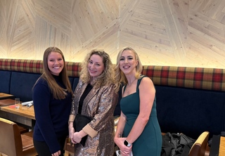 Three women smiling for camera
