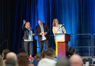 Three speakers on stage laughing
