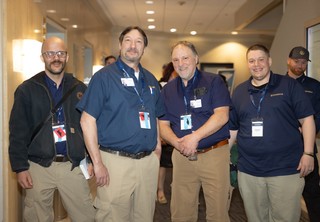 Four Guardian maintenance team members smiling at the camera