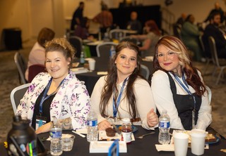 Three women posing for the camera and smiling