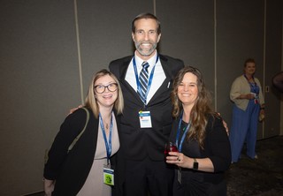 Three professionals smiling at the camera