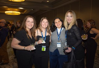 A group of four posing and smiling for the camera
