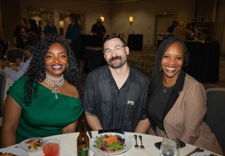 Three professionals dressed up and posing for the camera