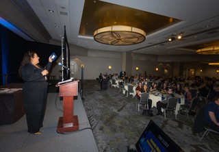 An award recipient on stage giving a speech to the crowd