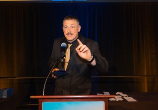 Close-up of a man on stage giving an award speech