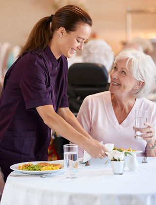 Dining room server assisting senior woman