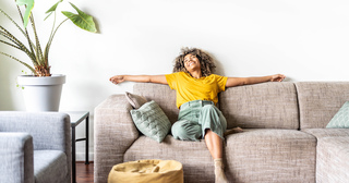 Woman stretched out on couch in happiness