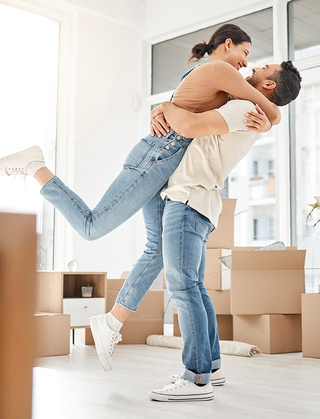 Couple embracing while unpacking in new apartment