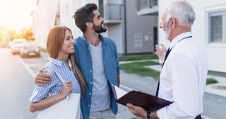 Couple and man discussing outside an apartment building