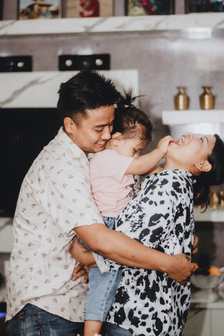 Father and mother embracing child