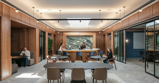 Office setting with tables and a bar counter with professionals working and talking together