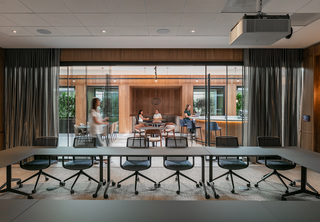 Looking out from large conference room with chairs and projector to open co-working space
