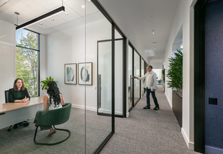 Office corridor with private offices and professionals working
