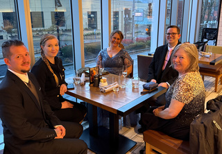Group celebrating at a table near a window