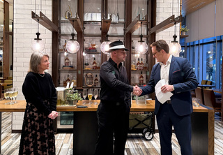 Robert shaking Josh's hand with Melody looking on