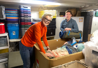 A woman and man organizing blankets at Rose Haven